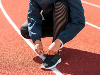 Close up of person tying laces on running shoes.